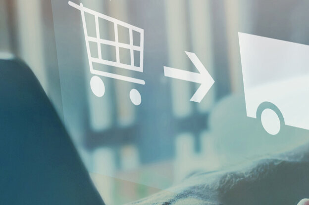 Shopping process with icons for shopping cart, delivery, and user, displayed above a laptop.
